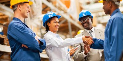 Warehouse manager shaking hands with warehouse worker