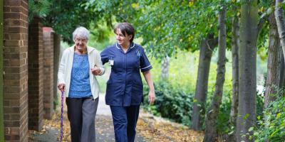 elderly woman walking with caregiver